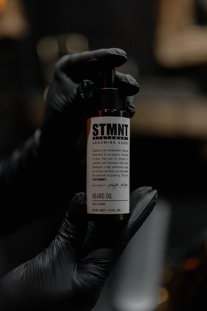 journey Stylish close-up of gloved hands holding a premium beard oil bottle.